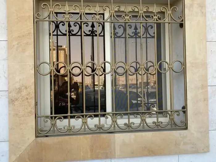 شبك حديد زخرفي لنافذة بتفاصيل ذهبية
